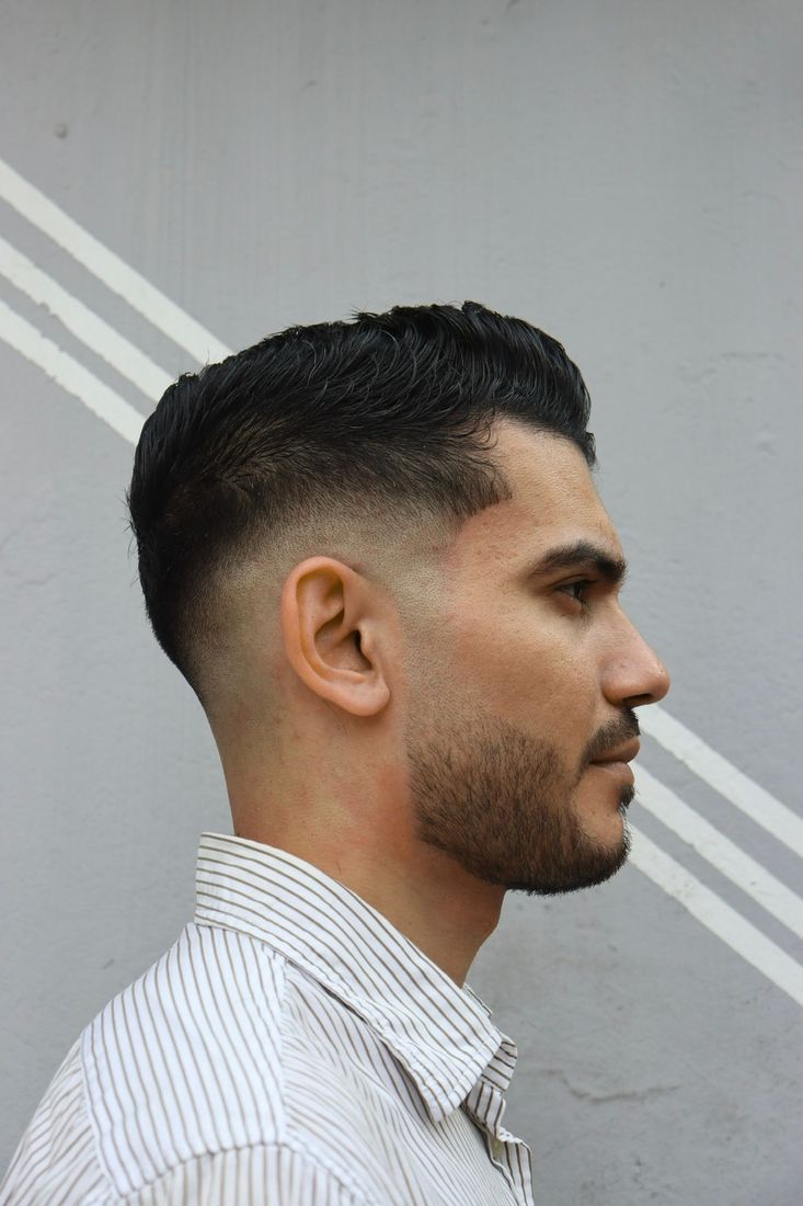 Corte con desvanecido medio y peinado hacia atrás, perfil completo.